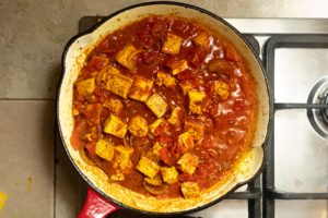 Tinned tomatoes added to pan