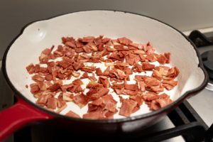 Vegan bacon pieces cooking in frying pan