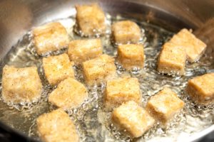 Tofu shallow frying in pan